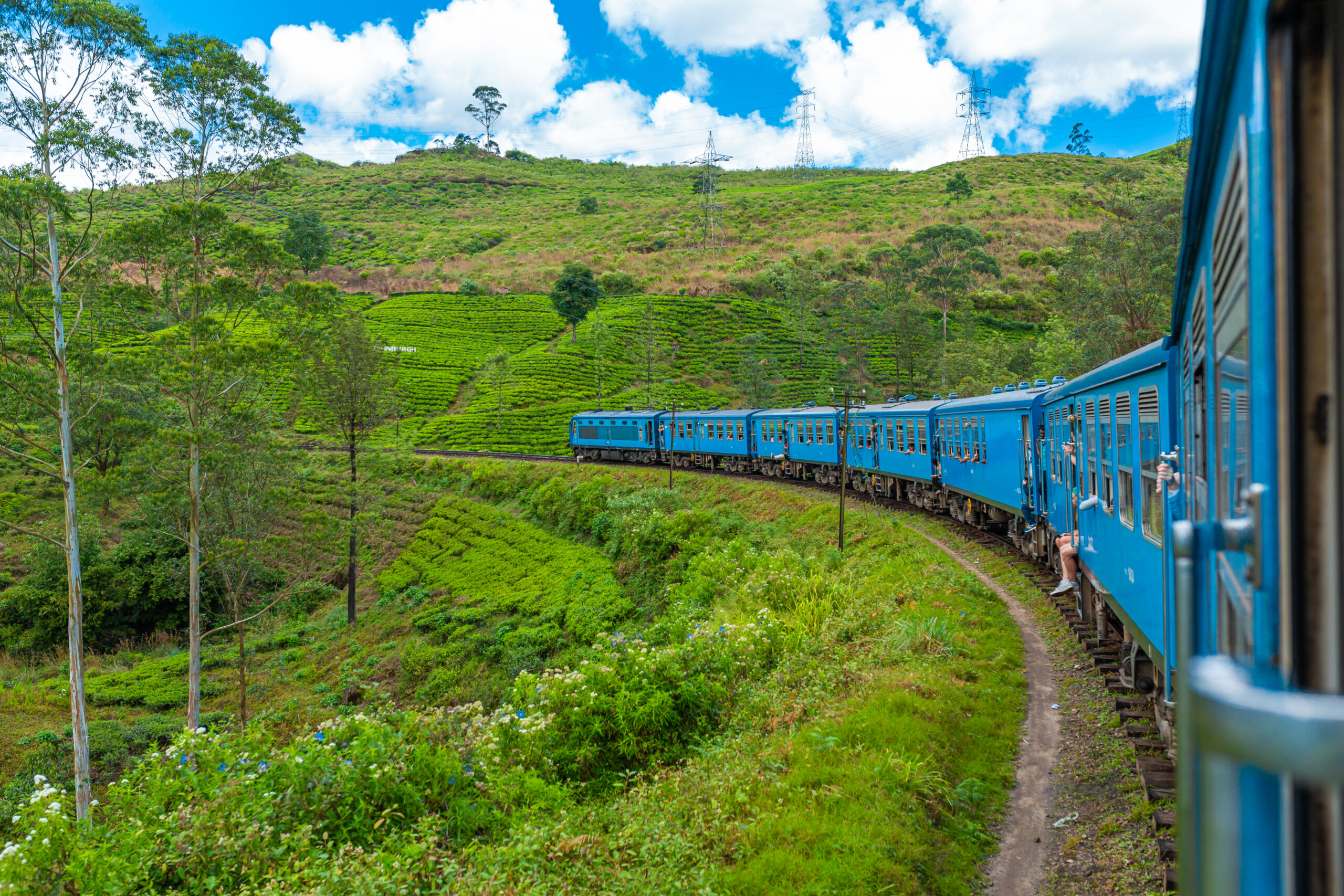 Travel by public train around the island of Sri Lanka. The train travels through mountains and tea plantations. Scenic railway.